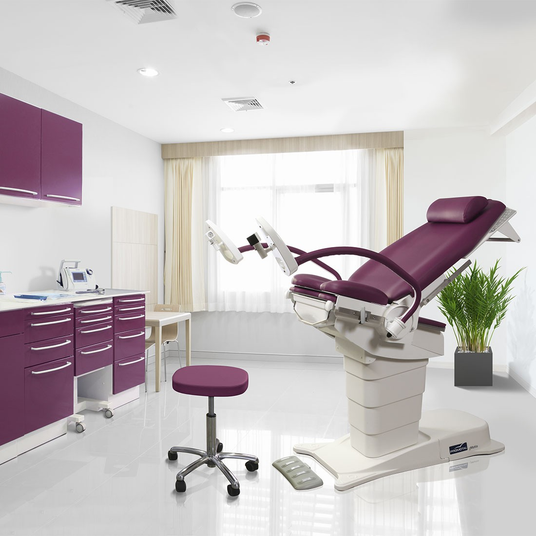 Divan gynécologique électrique GMOTIO couleur bordeaux dans cabinet